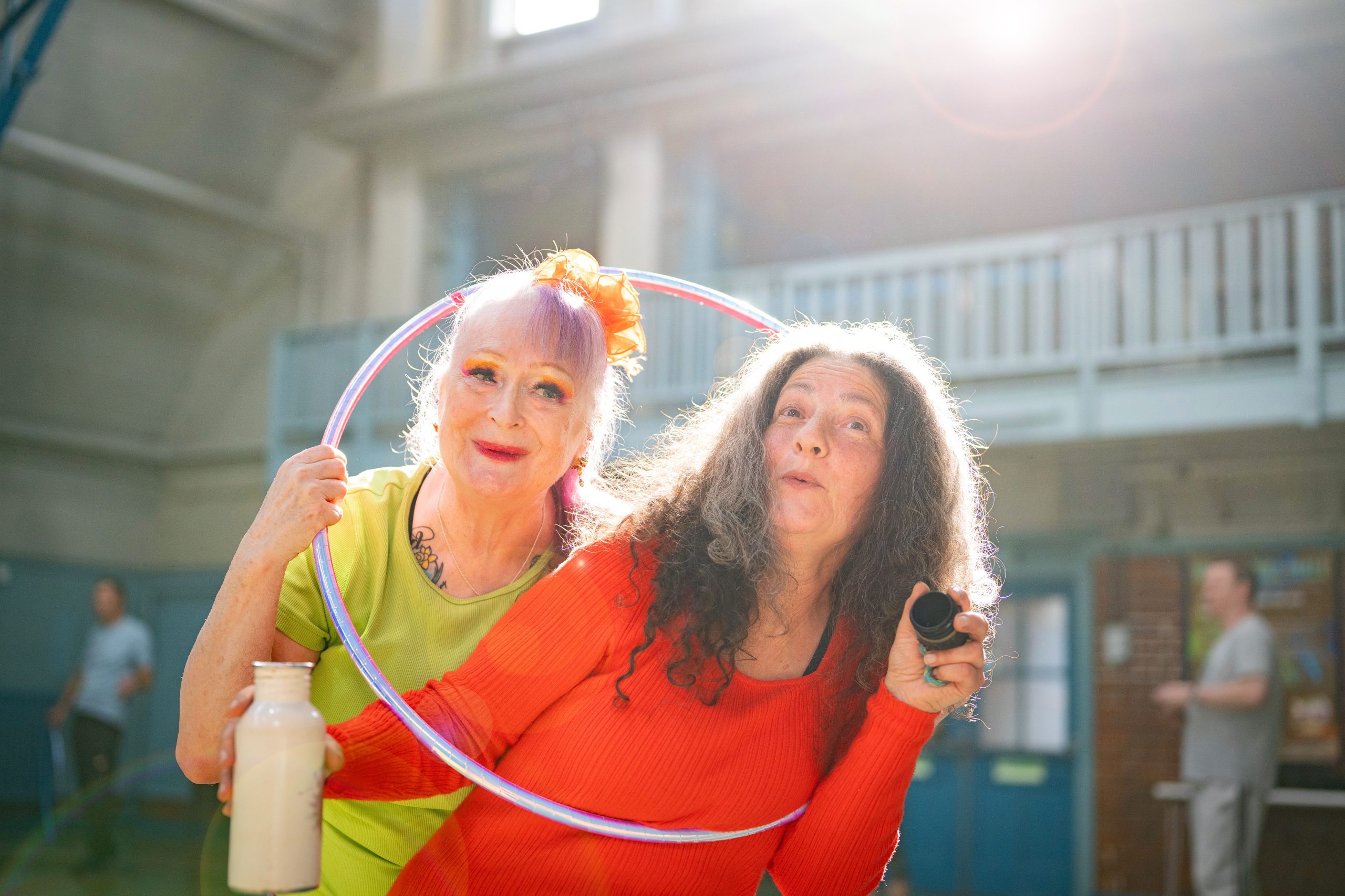 two older women in vibrant colors smiling and being slightly silly