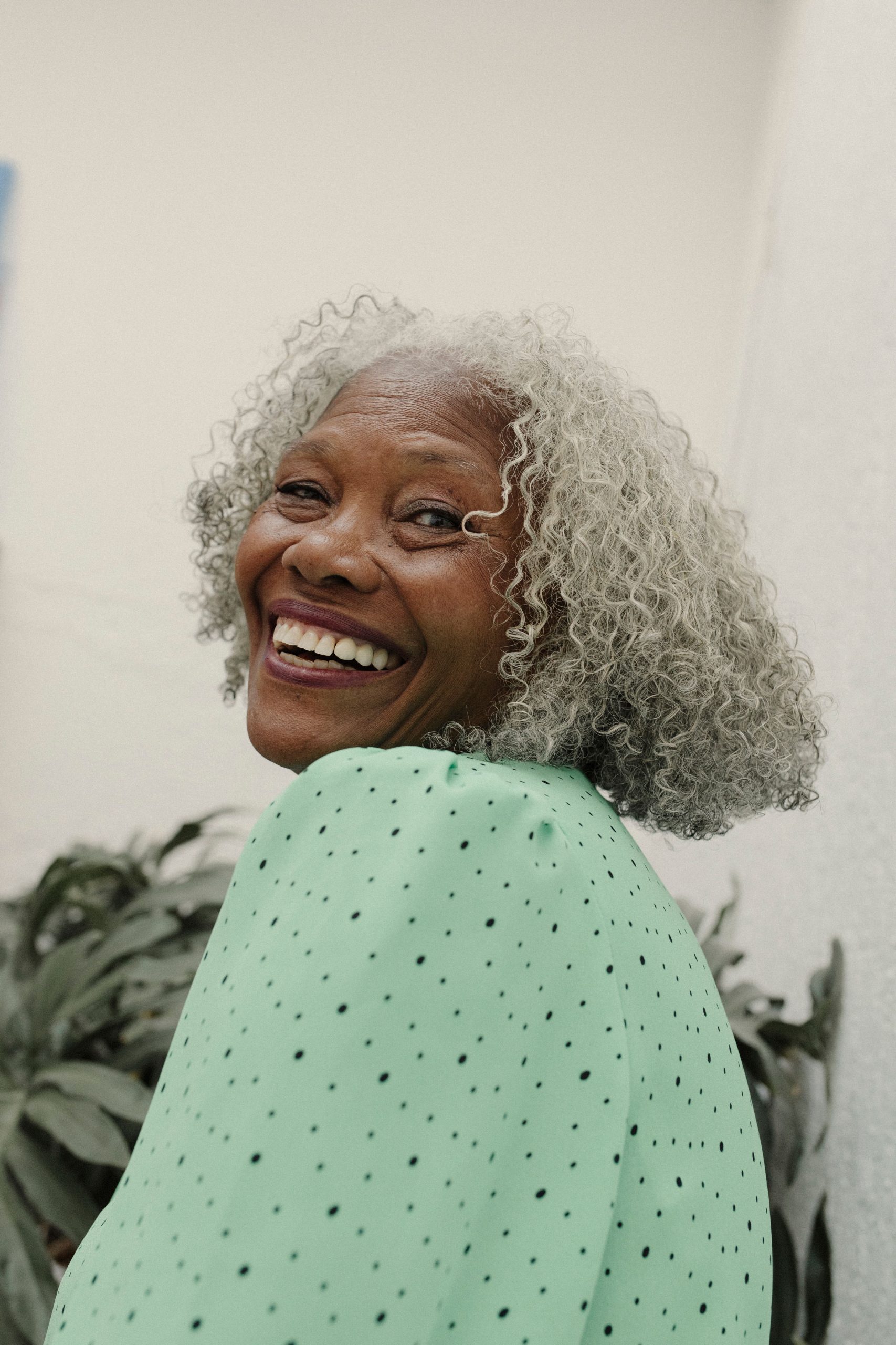 Radiant senior woman smiling outdoors in a vibrant green outfit